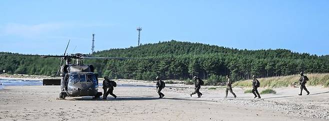 [서울=뉴시스] 육군특수전사령부는 2025년 UFS/TIGER의 일환으로 지난 25일부터 27일까지 충남 태안 안면도 해상훈련장 일대에서 '한미연합 해상침투훈련'을 실시했다.한미연합 특수작전능력 강화를 위해 실시된 이번 훈련에는 한미 장병 40여 명과 미측 F-16전투기 및 UH-60헬기 등이 투입되었다. 사진은 항공화력 유도로 적 시설을 성공적으로 제거한 특전대원들이 헬기를 이용해 작전지역을 이탈하는 모습. (사진=육군 제공) 2025.08.28. photo@newsis.com *재판매 및 DB 금지