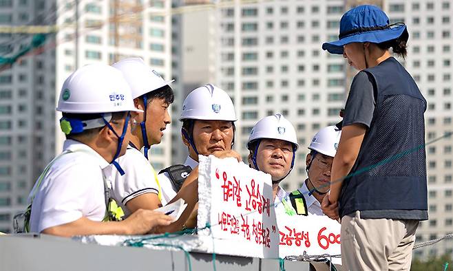 정청래(가운데) 더불어민주당 대표가 28일 경북 구미시 한국옵티칼하이테크를 방문해 599일째 고공농성 중인 박정혜 수석부지회장(금속노조 한국옵티칼하이테크지회)과 면담하고 있다. 더불어민주당 제공