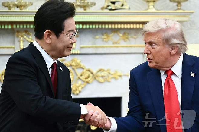 이재명 대통령이 25일(현지시간) 미국 워싱턴 백악관에서 도널드 트럼프 미국 대통령과 한미 정상회담에 앞서 악수하고 있다. ⓒ AFP=뉴스1 ⓒ News1 신웅수 기자