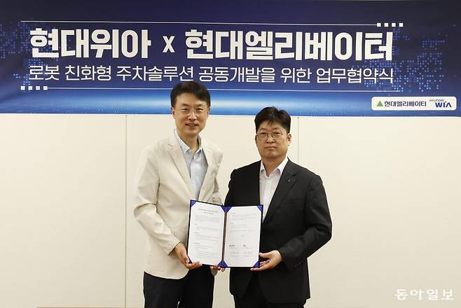 현대위아 모빌리티솔루션사업부 백익진 상무(왼쪽)와 현대엘리베이터 승강기사업본부장 이원해 상무가 28일 경기도 의왕시 현대위아 의왕연구소에서 열린 ‘로봇 친화형 주차솔루션 공동개발을 위한 업무협약식’에서 기념 사진을 찍고 있다. 두 회사 제공