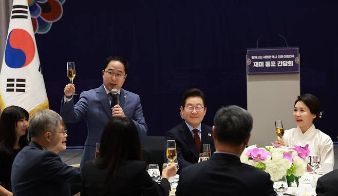 이재명 대통령(가운데)과 김혜경 여사가 24일(현지시간) 미국 워싱턴DC의 한 호텔에서 열린 동포 만찬 간담회에서 앤디 김 미국 상원의원(민주·뉴저지주)의 건배사를 듣고 있다.연합뉴스