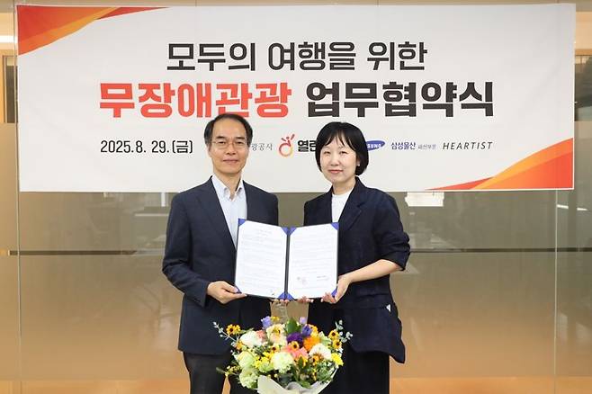 강규상 한국관광공사 관광복지안전센터장(왼쪽)과 신정원 삼성물산 패션부문 하티스트 그룹장이 무장애 관광 활성화를 위한 업무협약 후 기념촬영을 하고 있다. 한국관광공사 제공