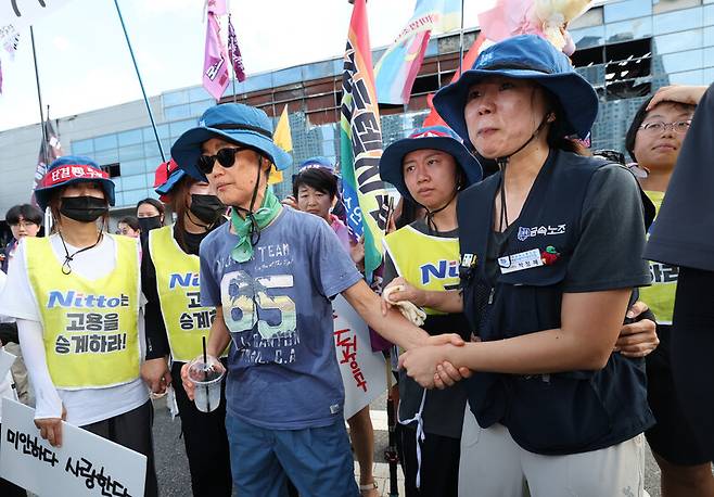 고용승계를 요구하며 600일간 고공농성을 이어갔던 박정혜 한국옵티칼하이테크 수석부지회장이 29일 경북 구미시 한국옵티컬하이테크 공장 옥상에서 농성을 마치고 땅으로 내려와 김진숙 민주노총 지도위원의 손을 잡고 있다. 김태형 기자 xogud555@hani.co.kr