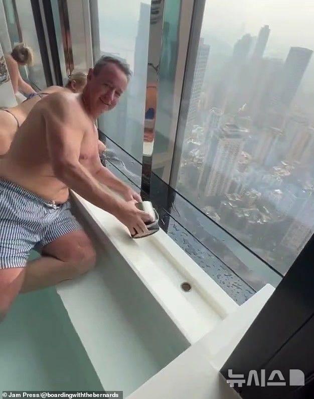 [뉴시스] 호주인 부부가 청소 직원들이 양동이로 물을 퍼내는 것을 돕고 있다. (사진=데일리메일) 2025.08.27.