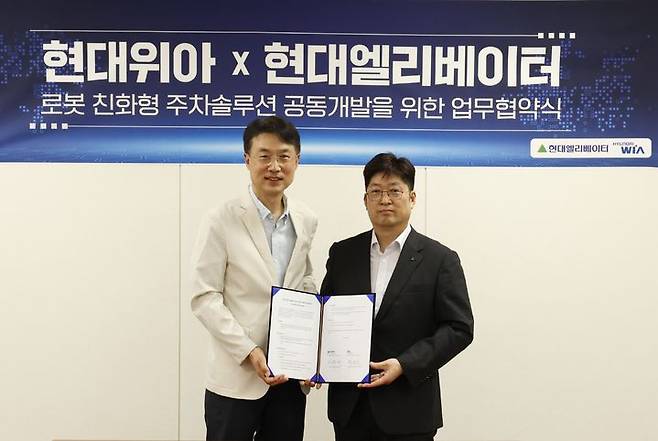 [서울=뉴시스] 지난 28일 경기 의왕시 현대위아 의왕연구소에서 열린 '로봇 친화형 주차솔루션 공동개발을 위한 업무협약식'에서 백익진 현대위아 모빌리티솔루션사업부 상무(왼쪽)와 현대엘리베이터 승강기사업본부장 이원해 상무가 기념 사진을 찍고 있다. (사진=현대위아 제공) 2025.08.29 photo@newsis.com *재판매 및 DB 금지