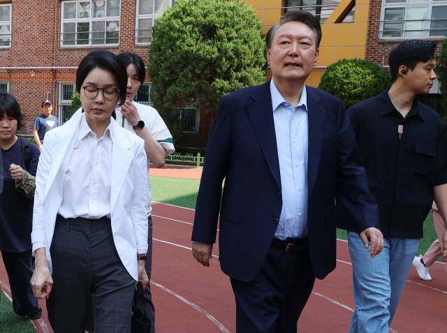 윤석열 전 대통령과 김건희 여사가 21대 대통령 선거일인 6월 3일 서울 서초구 원명초등학교에 마련된 서초4동 제3투표소에서 투표를 마친 뒤 차량으로 향하고 있다. 연합뉴스