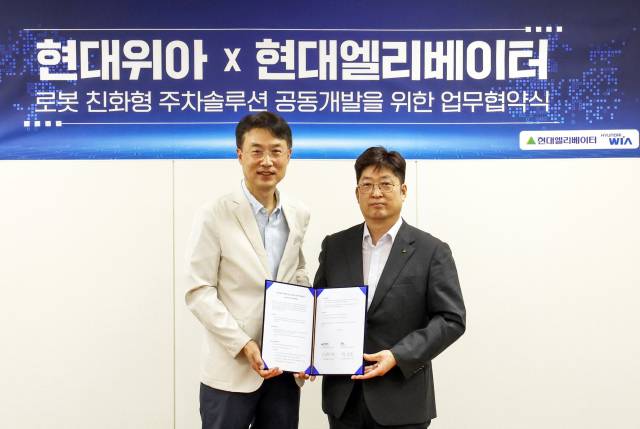 이원해(오른쪽) 현대엘리베이터 승강기사업본부장이 백익진 현대위아 모빌리티솔루션사업부장과 로봇 친화형 주차솔루션 공동개발을 위한 업무협약을 맺고 기념 촬영을 하고 있다. 사진 제공=현대엘리베이터