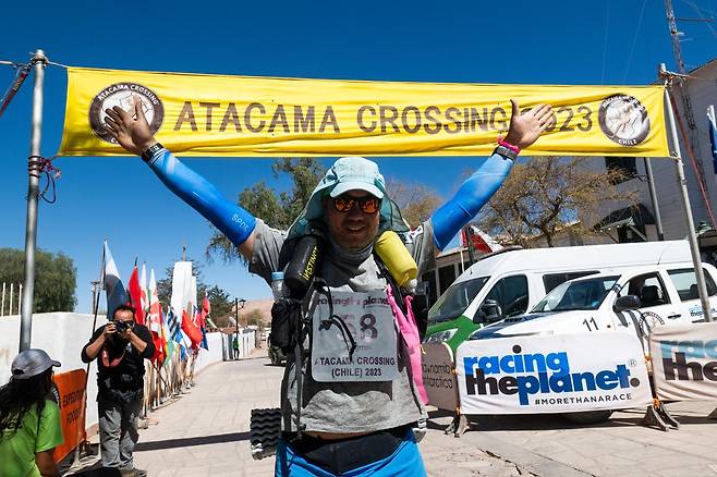 이종민 대표가 2023년 9월 칠레 아타카마사막 마라톤에서 결승선을 통과하며 양손을 번쩍 들어올리고 있다. 이종민 대표 제공.