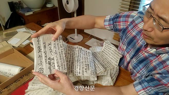 박건호씨가 수집품 가운데 장장 15m가 넘는 길이의 두루마리 회고록을 펼쳐 마지막 부분을 보여주고 있다. 펼쳤던 두루마리를 원래대로 되감는 데만도 거의 5분이 걸린다. 김지원 기자