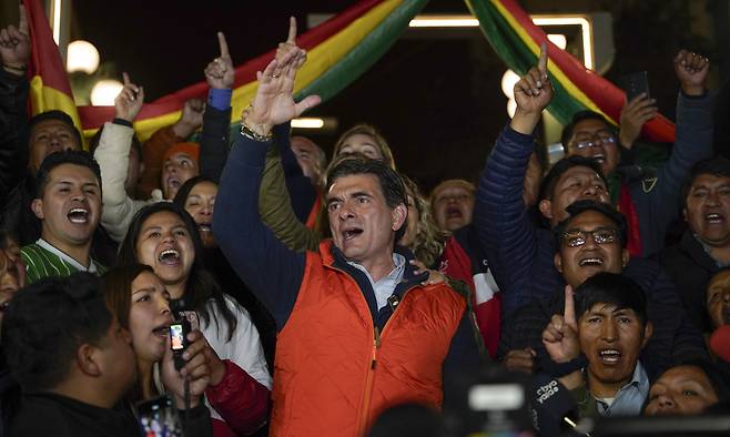 볼리비아 대선 1차 투표가 치러진 17일(현지시간) 수도 라파스에서 중도 성향의 로드리고 파스 기독민주당(PDC) 후보가 결선행을 확정지은 뒤 지지자들과 함께 환호하고 있다. 라파스=AP연합뉴스