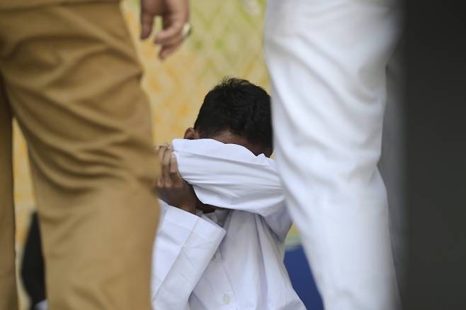공원 화장실에서 다른 남성과 키스해 샤리아(이슬람 율법)를 위반한 혐의로 유죄 판결을 받은 남성이 지난 26일(현지시간) 인도네시아 아체주 반다아체에서 진행된 태형 집행 후 바닥에 앉아 있다. 2025.8.26 AP 연합뉴스