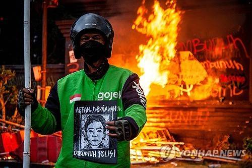 숨진 배달기사 초상화 든 동료  [AFP 연합뉴스. 재판매 및 DB 금지]