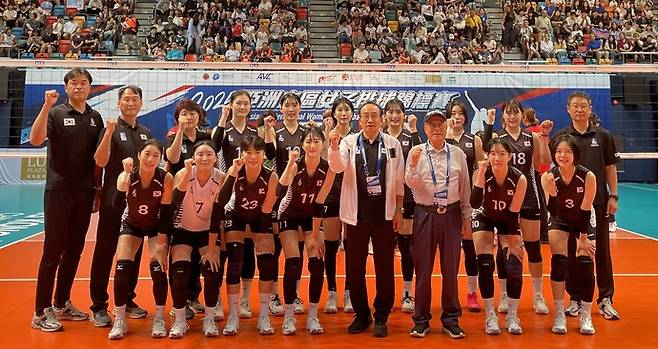 2025 동아시아 여자 배구 선수권대회서 동메달을 획득한 수원시청 선수단과 신현삼 단장, 박광국 수원시체육회장 등이 홍콩 퀸엘리베자스 경기장서 기념촬영을 하고 있다. 사진=수원시체육회