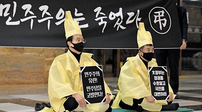 국민의힘 강민국(왼쪽), 최승재 의원이 2020년 국회의사당 중앙홀에서 상복을 입고 고위공직자범죄수사처법 개정안 강행 처리에 항의하고 있다. 이날 더불어민주당 등 여권은 야당의 거부권을 무력화하는 공수처법 개정안을 재석 287석 중 찬성 187명, 반대 99명, 기권 1명으로 가결시켰다. /국회사진기자단