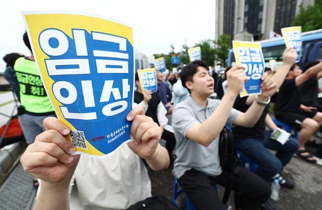 전국공무원노동조합 소속 공무원들이 7월 18일 서울 경복궁 인근에서 열린 집회에서 임금 인상을 호소하는 피켓을 들고 있다. 뉴스1