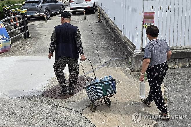 강릉 상수원 저수율 14.9%…샘터 찾은 시민들 (강릉=연합뉴스) 유형재 기자 = 31일 강원 강릉시 대관령샘터에서 시민들이 식수로 사용할 물을 받아 나오고 있다.
    롯데칠성음료에서 운영하는 대관령샘터는 대관령 지하 암반수를 취수해 수처리 과정을 거쳐 시민에게 식수를 제공하고 있다.
    강릉은 상수원인 오봉저수지의 저수율이 이날 기준 14.9%로 뚝 떨어지며 역대 최저치를 기록, 수도 계량기 75% 잠금 하는 강력한 제한급수가 시행되고 있다. 2025.8.31 yoo21@yna.co.kr