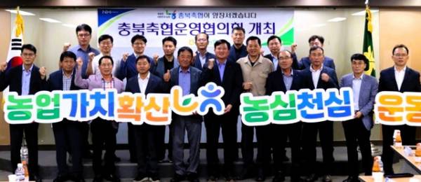 김홍기(앞줄 가운데 왼쪽) 의장과 이용선(오른쪽) 총괄본부장이 충북축협운영협의회 조합장들과 '農心天心' 운동을 펼치고 있다./충북농협 제공