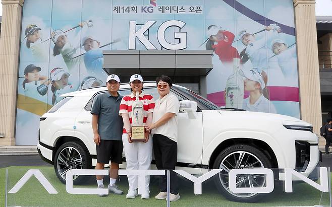 '제14회 KG 레이디스 오픈' 우승자 신다은 선수가 부상으로 받은 액티언 하이브리드 차량 앞에서 부모님과 기념 촬영을 하고 있다.