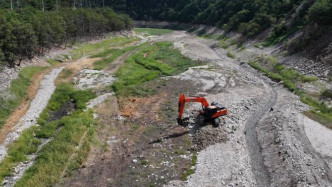 지난달 31일 강원 강릉시 주요 상수원인 오봉저수지 상류에서 한 관계자가 포크레인으로 물길을 내고 있다. /뉴스1