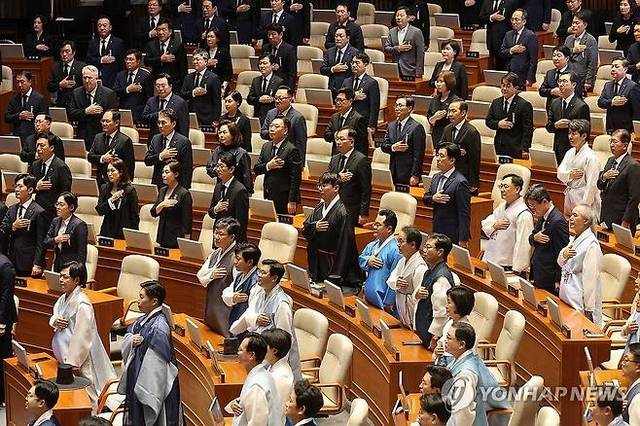1일 서울 여의도 국회에서 열린 정기국회 개회식에서 한복과 상복을 입은 여야 의원들이 국기에 대한 경례를 하고 있다. 연합뉴스