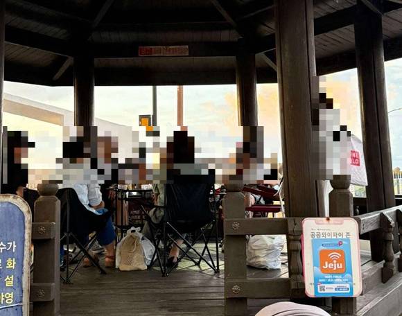 제주 현사포구 앞 정자에 캠핑 탁자와 의자를 가져온 관광객들이 논란이 됐다. [사진=보배드림]