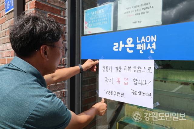 ▲ 강릉 라온초당펜션이 강릉시 가뭄 극복 동참을 위해 휴업에 들어갔다. 펜션 관계자가 1일 휴업 안내문을 붙이고 있다. 황선우 기자