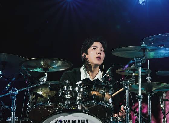 DAY6 member Dowoon plays drum during its 10th anniversary tour ″The Decade″ at the Goyang Stadium in Goyang, Gyeonggi, on Sunday. [JYP ENTERTAINMENT]