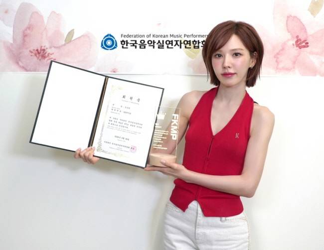 Wendy of girl group Red Velvet holds up her new membership of the Federation of Korean Music Performers on Sept. 1. [FEDERATION OF KOREAN MUSIC PERFORMERS]