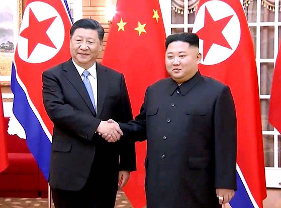 Chinese President Xi Jinping, left, on a state visit to North Korea, shakes hands with North Korean leader Kim Jong-un ahead of a bilateral summit at the Kumsusan State Guest House in Pyongyang on June 20, 2019. [SCREEN CAPTURE]