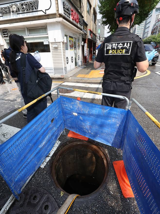 25일 서울 염창동 맨홀에서 작업자 한 명이 내부로 휩쓸려 가는 사고가 발생, 관계자들이 현장에서 조사를 하고 있다. [연합]