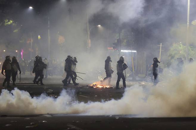 [수라바야=AP/뉴시스] 지난달 30일(현지 시간) 인도네시아 동부자바 수라바야에서 경찰이 최루탄으로 시위대 해산을 유도하고 있다. 고액의 국회의원 주거 수당에 항의하는 시위가 일주일 가까이 이어지자, 프라보워 수비안토 인도네시아 대통령은 31일 수당을 폐지하겠다며 타협안을 제시했다. 2025.09.01.