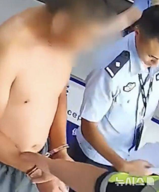 [뉴시스]경찰 조사 결과 지명수배범이 확인된 후 연행되고 있는 모습.(사진=인민일보)