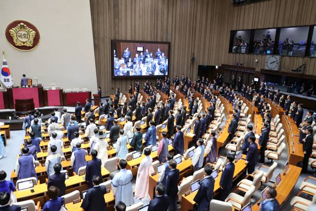 1일 서울 여의도 국회 본회의장에서 열린 제429회 정기국회 개회식에서 의원들이 국기에 경례하고 있다. 이날 더불어민주당을 비롯한 여야 대부분 의원들은 한복 차람으로, 국민의힘 의원들은 여당에 항의하는 차원에서 근조 리본을 달고 상복 차림으로 개회식에 참석했다. 연합뉴스