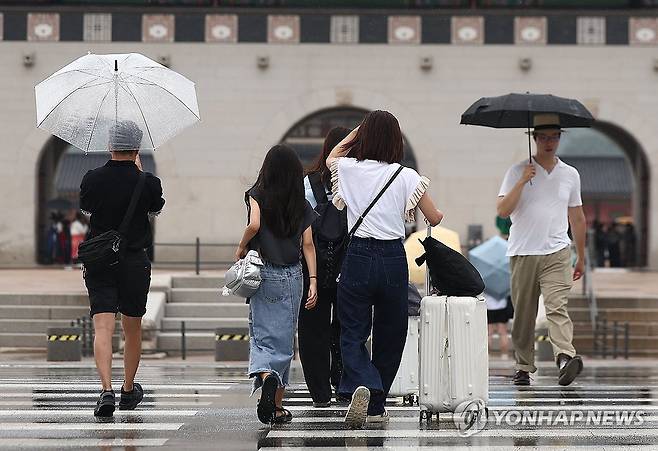 광화문에 내리는 소나기 (서울=연합뉴스) 김성민 기자 = 소나기가 내린 25일 오전 서울 종로구 광화문 인근에서 외국인 관광객이 비를 피하고 있다. 2025.8.25 ksm7976@yna.co.kr