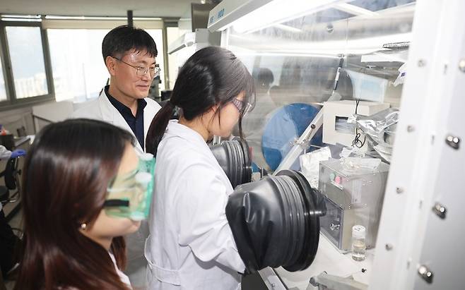 울산대학교 에너지화학공학부 오은석 교수와 연구팀이 글로브 박스를 통해 외부 환경과 차단된 상태로 이차전지 실험을 수행하고 있는 모습. 울산대 제공