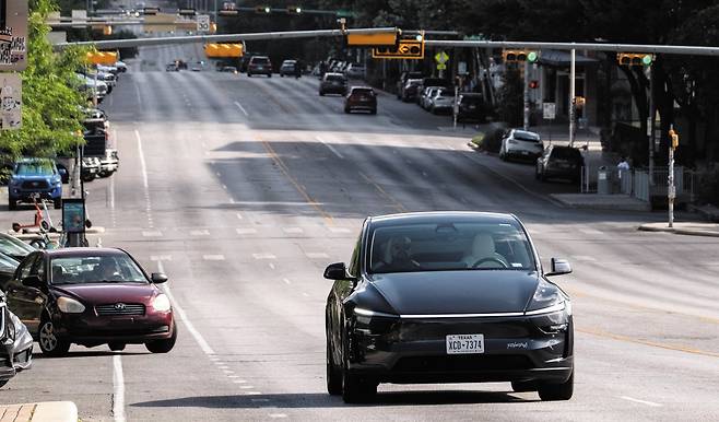 지난 6월 미 텍사스주 오스틴의 한 도로에서 테슬라의 로보(무인) 택시가 승객을 태우고 운행하고 있다. 이날 테슬라는 사전에 초청한 승객을 대상으로 오스틴의 일부 지역에서 로보 택시 서비스를 시작했다. /로이터 연합뉴스