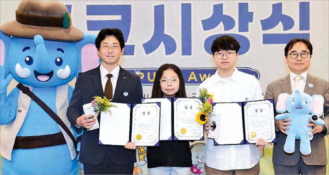 ‘제6회 푸른코끼리와 함께하는 학교·사이버 폭력 예방 공모전 시상식’에서 장덕현 삼성전기 사장(오른쪽부터), 삼성전기 대표이사상을 받은 김준형 군(세종과학예술영재학교 3학년), 이주아 양(동탄초 5학년), 진유현 양지고 교사가 상장과 마스코트를 들어 보이고 있다.  삼성전기 제공