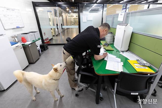 신종필 양성교관이 화약 시료 훈련을 준비하는 동안 임회가 신 교관의 허리춤에 달린 파우치 속 간식 냄새를 맡고 있다.