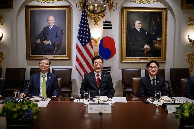 태극기와 성조기를 배경으로 나란히 앉은 조현 외교부 장관, 이재명 대통령, 김정관 산업통상자원부 장관.(왼쪽부터) 백악관