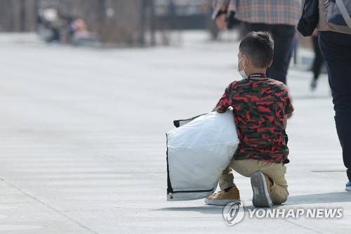 햇볕 아래 앉아 있는 아이 [연합뉴스 자료사진]