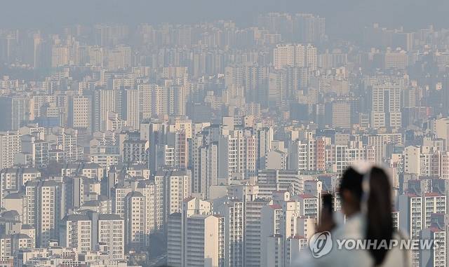 한 시민이 서울 아파트 밀집 지역을 촬영하고 있다.[연합뉴스]
