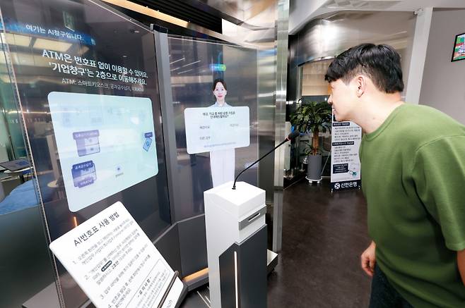 입구에서 AI 은행원의 안내에 따라 업무를 선택하고 있다.