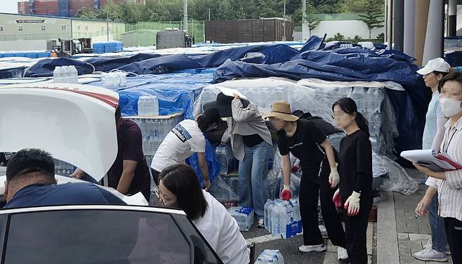 지난달 29일 강원도 강릉시 강릉아레나 주차장에서 강릉시청 직원들이 가뭄으로 어려움을 겪는 학교, 경로당, 유치원 등에 생수를 배부하고 있다. 연합뉴스