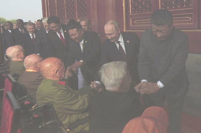 [베이징=AP/뉴시스] 시진핑(오른쪽부터) 중국 국가주석, 블라디미르 푸틴 러시아 대통령, 김정은 북한 국무위원장이 3일(현지 시간) 중국 베이징의 톈안먼 광장에서 열리는 '중국 인민 항일 전쟁 및 세계 반파시스트 전쟁 승리(전승절)' 80주년 기념 열병식을 앞두고 원로들과 인사를 나누는 모습이 대형 모니터에 비치고 있다. 2025.09.03.