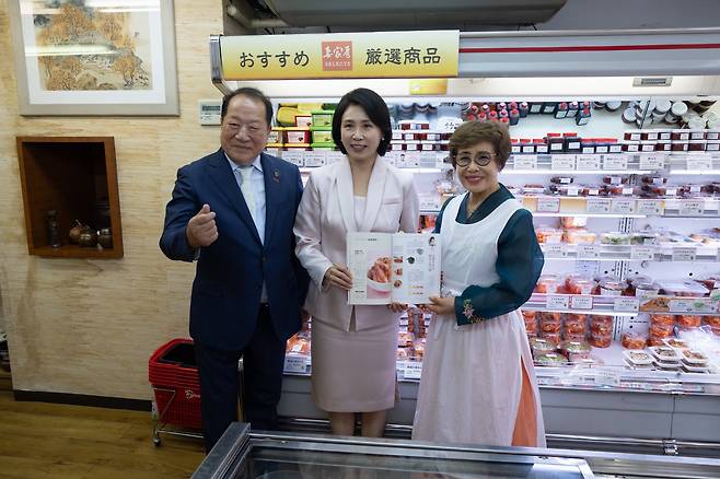 24일 김혜경 여사가 일본 도쿄의 한식당 내 반찬 판매 코너를 방문해 관계자들과 기념 사진을 촬영하고 있다. 대통령실 제공