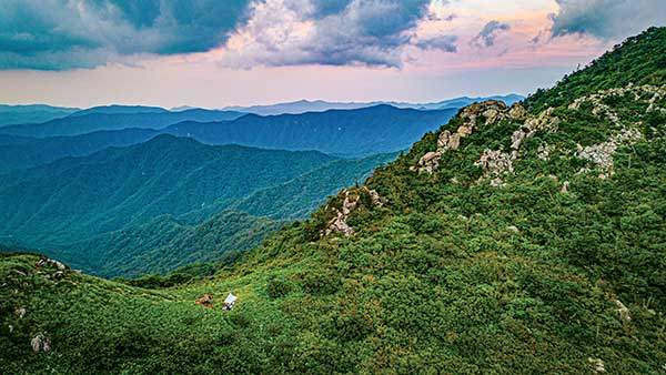 노을지는 배달은석 야영지. 주억봉으로 이어지는 등산로는 암릉이 즐비하다. 비가 내리는 다음날 아침은 위험해서 우회길을 이용했다.