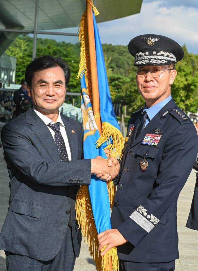 손석락 공군참모총장이 안규백 국방부장관으로부터 지휘권을 상징하는 공군기를 전달받고 있다. 사진 제공=공군