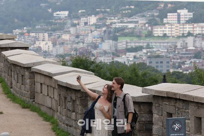 지난 24일 서울 종로구 낙산공원 성곽길에서 외국인 관광객들이 인증사진을 찍고 있다. 낙산공원 성곽길은 극 중 주인공 루미와 진우가 데이트했던 장소다. 영화가 흥행하면서 낙산공원, 남산 서울타워 등 영화 속 서울 명소에 외국인 관광객이 몰리고 있다. [이데일리 이영훈 기자]
