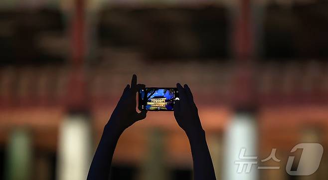 경복궁 야간 관람이 시작된 3일 오후 서울 종로구 경복궁을 찾은 시민이 경회루를 스마트폰으로 촬영하고 있다.  2025.9.3/뉴스1 ⓒ News1 김진환 기자