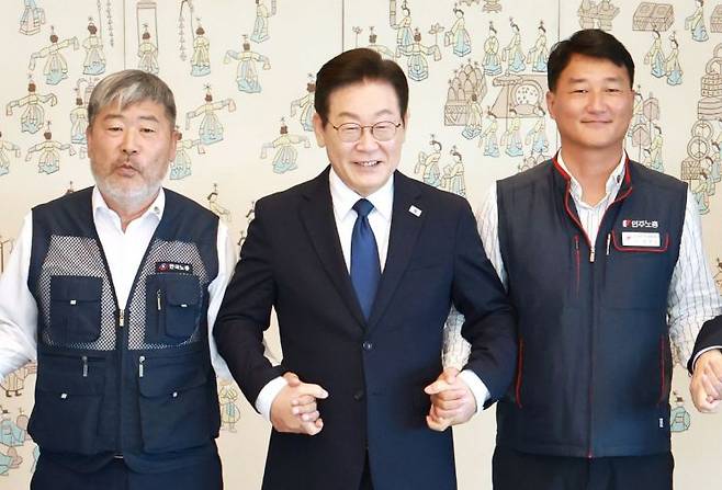 이재명 대통령이 4일 서울 용산 대통령실 청사에서 열린 양대노총 위원장과의 오찬 간담회에 참석해 김동명 한국노총 위원장(왼쪽), 양경수 민주노총 위원장과 기념촬영을 하며 손을 잡고 있다. 연합뉴스